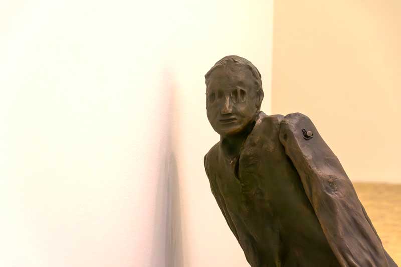 Escultura de Juan Muñoz, hombre escuchando la pared