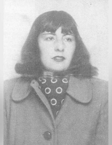 Fotografía en blanco y negro de María Luisa Bombal, tomada de su pasaporte. Ella es una mujer joven con cabello oscuro hasta los hombros, peinado en un bob con flequillo. Mira directamente a la cámara con una expresión seria. Viste un abrigo oscuro con solapas anchas y debajo, un pañuelo de cuello con un patrón de lunares o círculos blancos. La foto tiene un aspecto vintage y está enmarcada por bordes grises y borrosos.