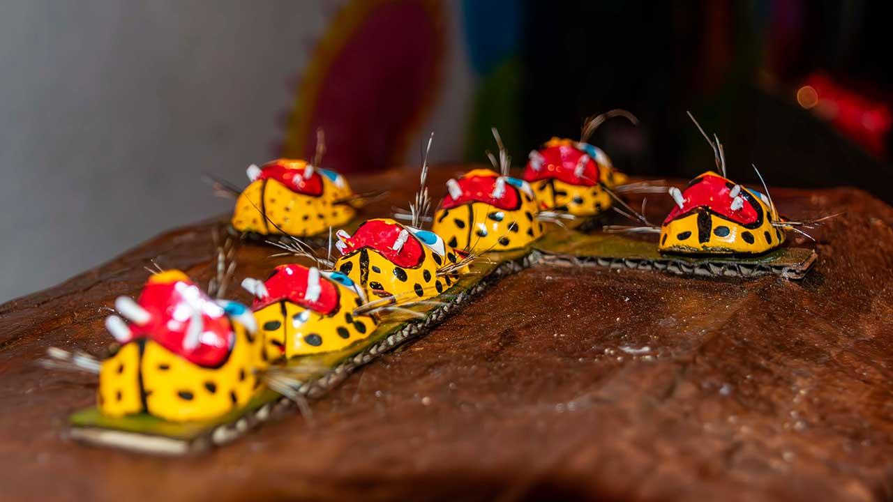 Obra ‘Guerrero es una cajita’ de Manuel Maciel: simulación de ataúd café con cruces de máscaras de jaguar, representando el dolor cotidiano y la memoria histórica de Guerrero en su exposición de arte conceptual en Acapulco.