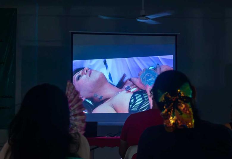 Personas asistentes al documental Kenya en Acapulco observan la escena en la que Kenya Cuevas yace en un ataúd durante una protesta por justicia para su amiga asesinada.