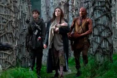 Grupo de supervivientes camina entre estructuras óseas en un entorno postapocalíptico en la película 28 Años Después.