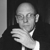 Retrato de Michel Foucault, filósofo francés, con gafas y una expresión pensativa.